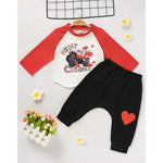 Close-up of baby boy's white and red long sleeve T-shirt with 'Heart Crusher' monster truck print for Valentine's Day.