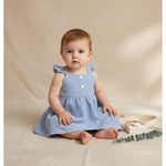 Toddler Girl Summer Outfit Featuring Toddler girl sitting down in a blue and white striped summer dress with ruffle sleeve straps