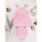 A cute toddler girl's pink and white striped summer outfit featuring a ruffle sleeve top and matching shorts, laid flat on a white surface with roses.