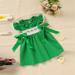 Toddler girl in green ruffle sleeve bow dress at birthday party