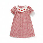 Toddler girl wearing a plaid smocked dress with embroidered collar and puff sleeves for school.
