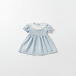 toddler girl wearing a smocked princess dress with puff short sleeves and lace crew neck.